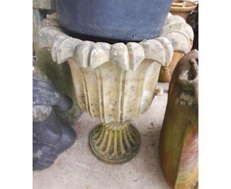 A large concrete planter with leaf/petal design  