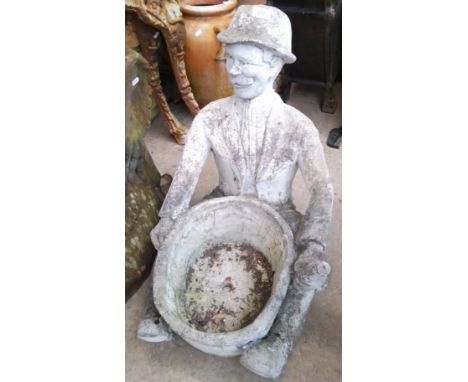 A concrete planter with sitting gent holding planter  