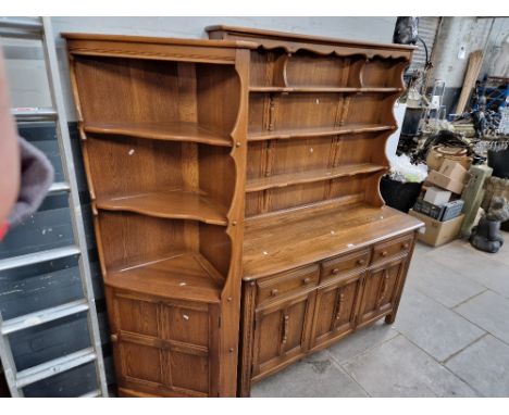 An Ercol elm dresser with plate rack back, together with a matching corner cabinet.  