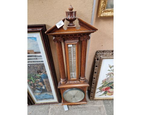An oak framed barometer/thermometer.  