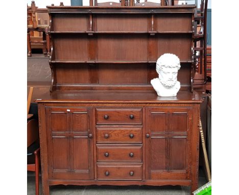An Ercol oak dresser with plate rack back.  