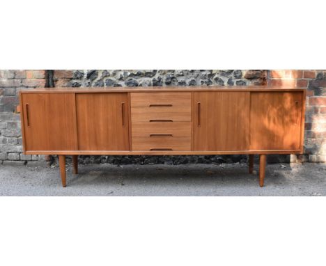 A mid century Swedish teak sideboard by Nils Jonsson for Troeds, of rectangular outline, fitted with twin sliding doors enclo