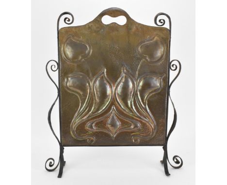 An Arts &amp; Crafts hammered copper fire screen, with embossed stylised motif, pierced handle to the top and scrolled ends, 