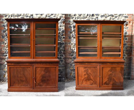 A pair of Victorian flame mahogany bookcases, with moulded cornice, glazed double doors opening to a single shelf above a twi