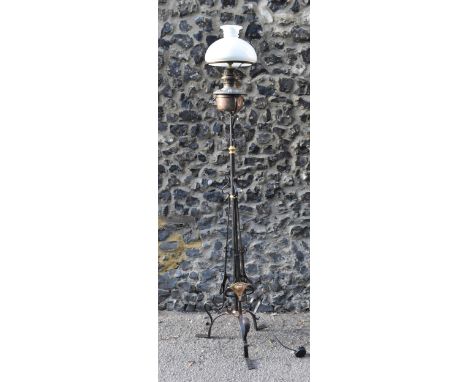 An Arts and Crafts wrought iron, copper and brass floor standing lamp, circa 1920s, with forge wrought whiplash scrolls and b