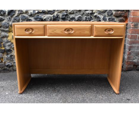 A blonde elm Ercol desk, of rectangular form with three frieze drawers, label to to the back, 77 cm high x 110 cm wide x 45 c