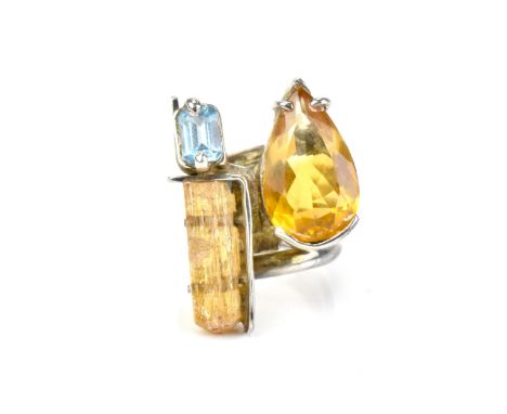 A contemporary silver-mounted citrine, blue topaz and raw imperial topaz dress ring by a Brazilian designer, in the modernist