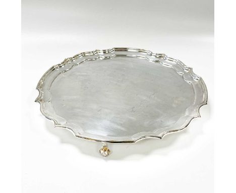 An Elizabeth II silver salver, mark of Sterling Silverware Ltd., Sheffield 1976, 'Chippendale' style, raised on three scroll 