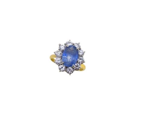 An 18ct gold sapphire and diamond cluster ring, claw set oval faceted sapphire, approximately 9.8 x 6.95 x 5.35mm, estimated 