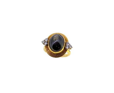 A late 20th century 18ct gold star sapphire and diamond ring, rubover set oval cabochon black star sapphire, approximately 11