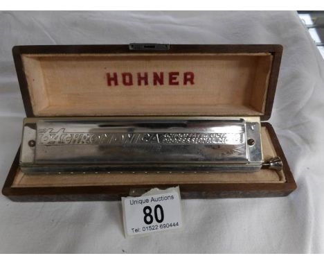 A cased Hohner 64 Chromonica professional harmonica