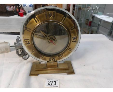 An Art Deco glass and brass clock with electric movement and in working order