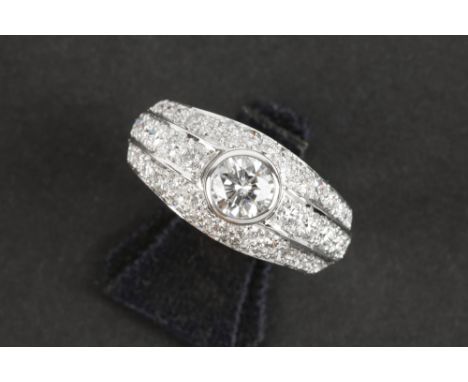 classy ring in white gold (18 carat) with a high quality brilliant cut diamond of 0,65 carat and with ca 1,60 carat of small 