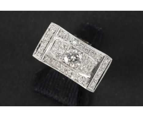fifties' late Art Deco ring in grey gold (18 carat) with a central 0,50 carat high quality brilliant cut diamond and ca 0,60 
