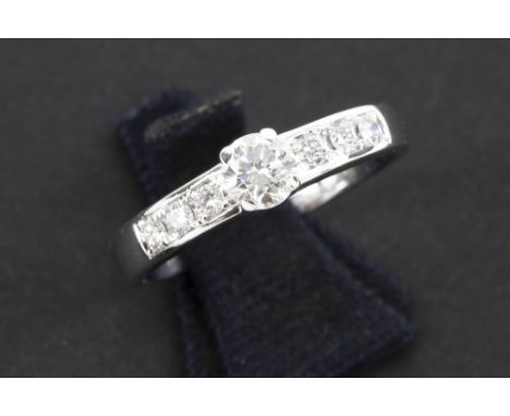 a 0,35 carat brilliant set in a ring in white gold (18 carat) with small briliants - in total : ca 0,55 carat of high quality