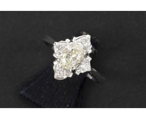 ring in white gold (18 carat) with a 0,59 carat quality oval brilliant cut diamond surrounded by ca 0,20 carat of small high 
