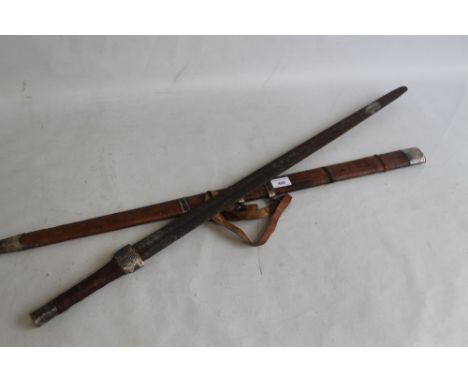 A VINTAGE TRIBAL SWORD, with white metal fittings and hide covered scabbard