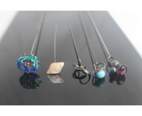 FIVE EDWARDIAN HAT PINS, to include a Charles Horner thistle top, and an enamel top example