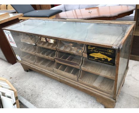 A VINTAGE HABERDASHERY SHOP CABINET WITH GLAZED TOP, FRONT AND SIDES, SIXTEEN GRADUATED DISPLAY DRAWERS AND BRASS YARD STICK 