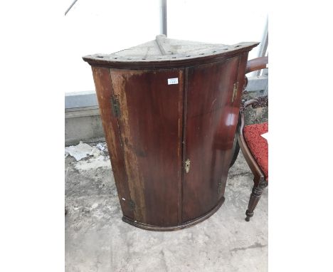 A BOW FRONT MAHOGANY CORNER CUPBOARD WITH BRASS H HINGES 