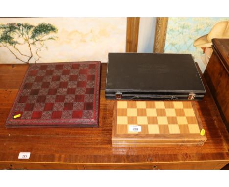 A backgammon set; a draughts set; and a decorative chess board 