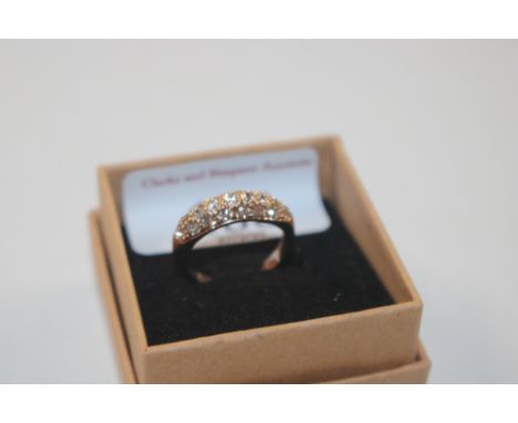 A yellow metal and white stone set ring