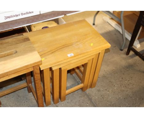 A nest of three light oak occasional tables
