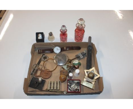A tray of miscellaneous items to include glass bottles ad stoppers, cigarette lighter, wrist watch, cased thimble, miniature 