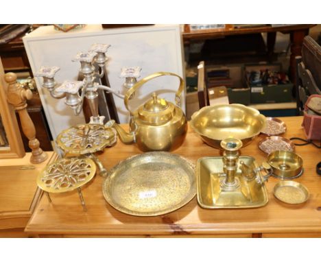 An antique brass chamber stick; brass kettle; two brass trivets; brass and copper trays; and a plated candelabra etc.