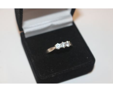 A silver ring set with three white stones 