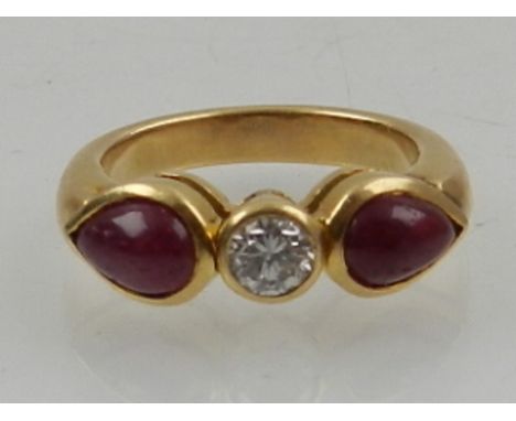 An 18 carat yellow gold, diamond, and ruby ring, set central round cut diamond of approx. 0.25 carats, flanked by two pear cu