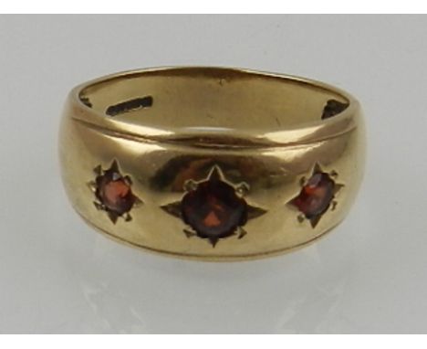 A 9 carat yellow gold and ruby 'gypsy' ring, set three round cut rubies. 