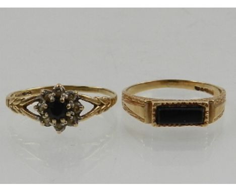 A 9 carat yellow gold and onyx set ring, together with a 9 carat yellow gold, diamond, and sapphire floral cluster ring. (2) 