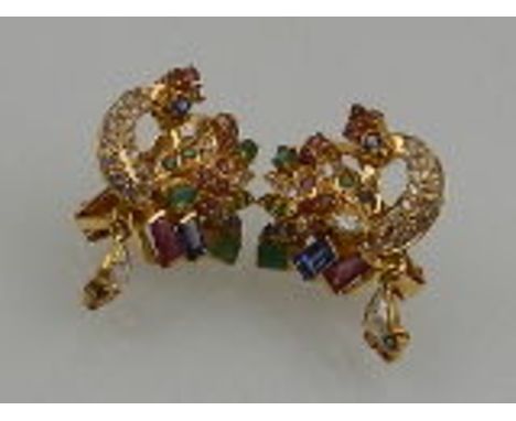 A pair of yellow metal, emerald, ruby, sapphire, and white topaz peacock earrings, each suspended with a pear cut white topaz