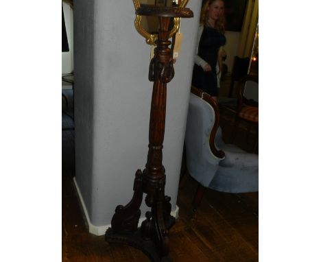 A 20th century Continental walnut pedestal, having a turned column support and raised on tripod legs and trefoil base. H: 148