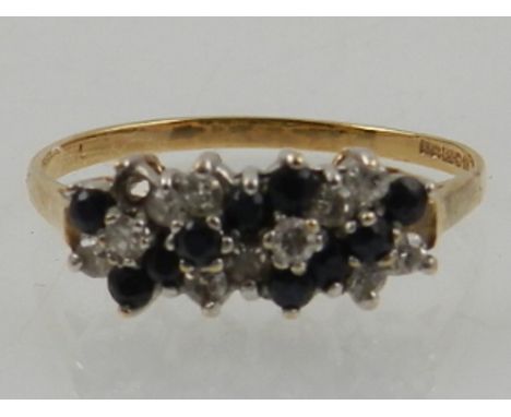 A 9 carat yellow gold and blue and white sapphire ring, set alternating rows of round cut sapphires. 