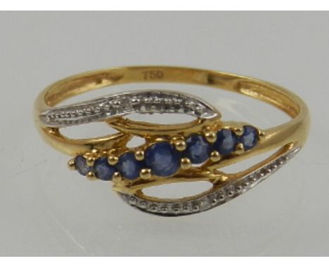 An 18 carat yellow gold, sapphire, and diamond crossover style ring. 