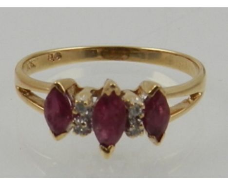 A 10 carat yellow gold, ruby and diamond ring, set three marquise cut rubies and four small round cut diamonds. 