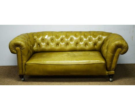 A late Victorian green buttoned and studded leather drop-end Chesterfield sofa, turned feet, on later castors, 197 x 90 x 73c