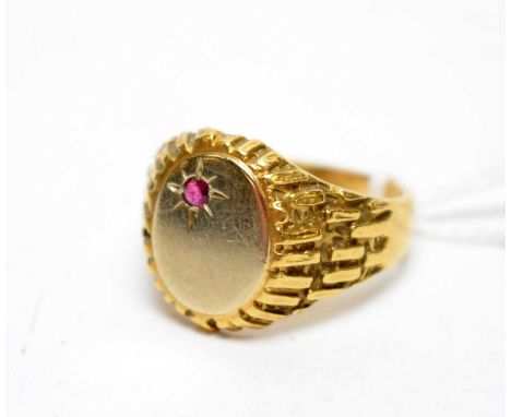 A yellow metal signet ring, set with ruby to blank matrix above textured shoulders, 9.7g gross, ring size X.
