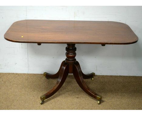 A George III rectangular mahogany and rosewood banded tilt-action dining table, on ring and baluster turned stem, fitted four