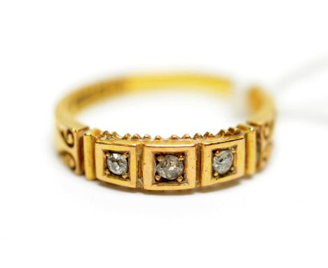 A late Victorian diamond ring, the three graduated old cut diamonds in square mount flanked by scrolling shoulders on 18ct ye