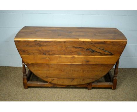 A 20th Century yew wood drop leaf dining table, the rectangular top with two drop leaves, raised on baluster and ring turned 