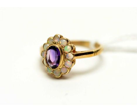 An amethyst and opal cluster ring, the central oval faceted cut amethyst surrounded by circular opal cabochons, on 9ct yellow