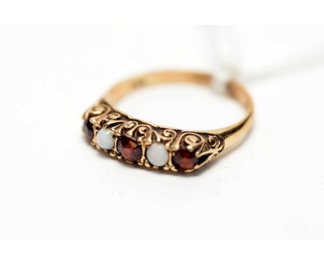 An opal and garnet ring, in scrolling mount on 9ct yellow gold shank, ring size O.