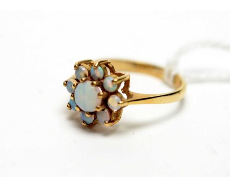 An opal cluster ring, set with nine circular opal cabochons, on 9ct yellow gold shank, ring size R.