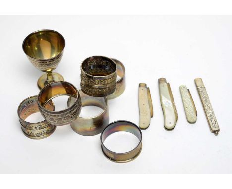 A selection of silver napkin rings and other items, to include: a matching egg cup and napkin ring, by Walker and Hall, Sheff