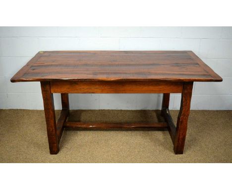 A substantial oak refectory dining table in a rustic 19th Century style, the four-plank rectangular top raised on shaped squa