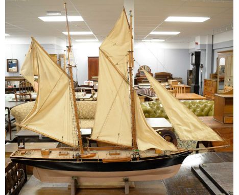RYS Waterwitch model pond yacht, painted in black and beige, on mahogany base, approximately 137cms long.