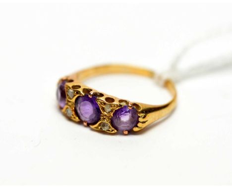 An amethyst and diamond ring, the three graduated circular facet cut amethysts parted by rose cut diamond pairs, the yellow m